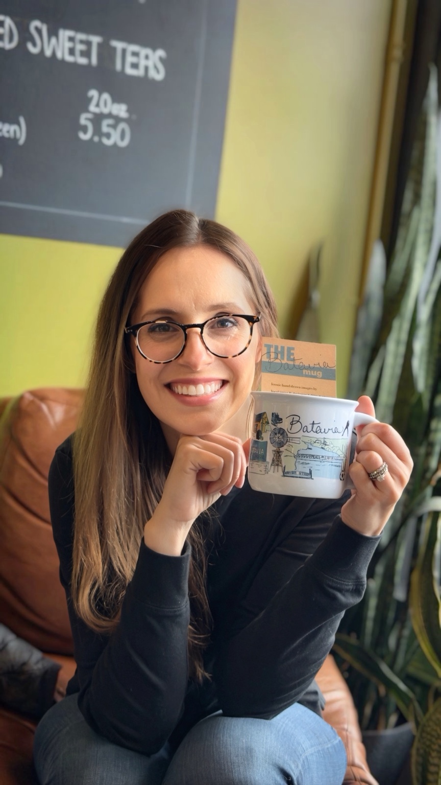 Artist Ashley Ann holding The Batavia Mug inside Limestone Coffee and Tea
