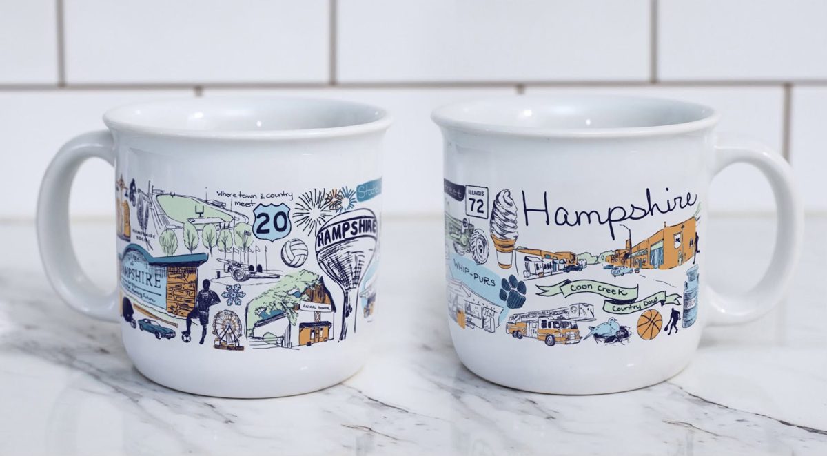 Two Hampshire mugs showing the water tower, downtown streetscape, festival details, highway signs, and Whip-Pur symbols in Ashley Ann’s original design