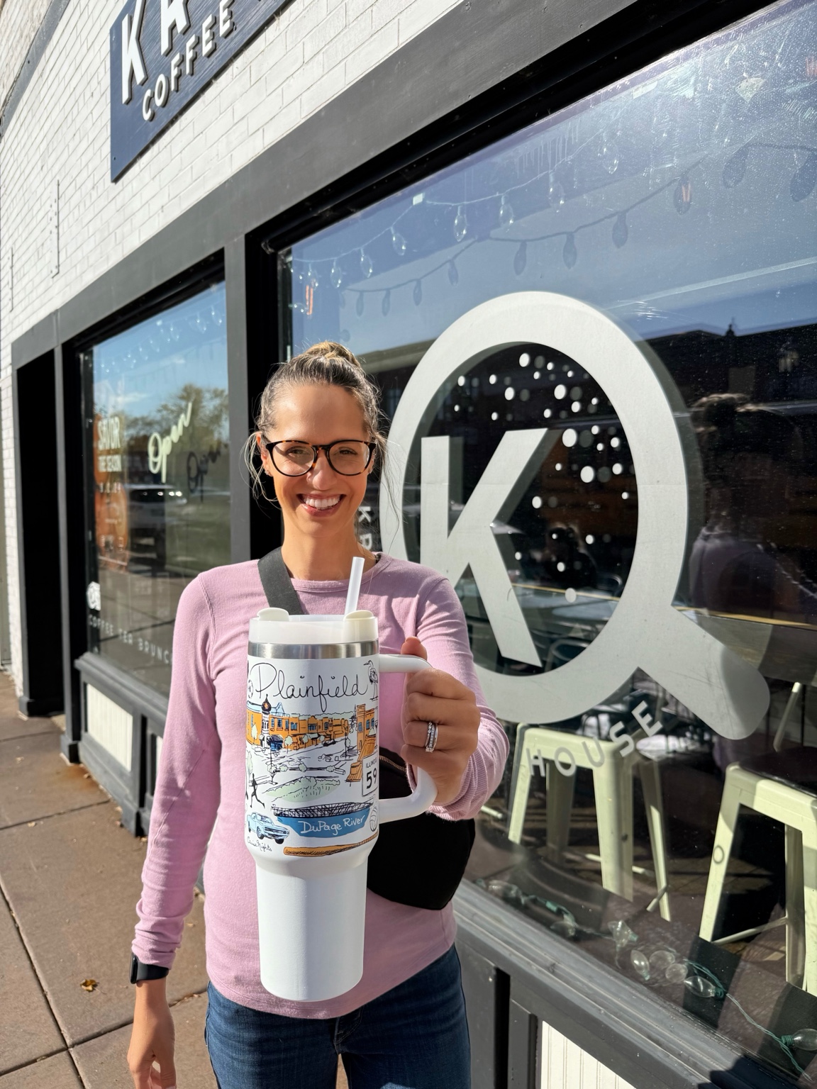 Ashley holding the Plainfield tumbler outside Krema Coffee