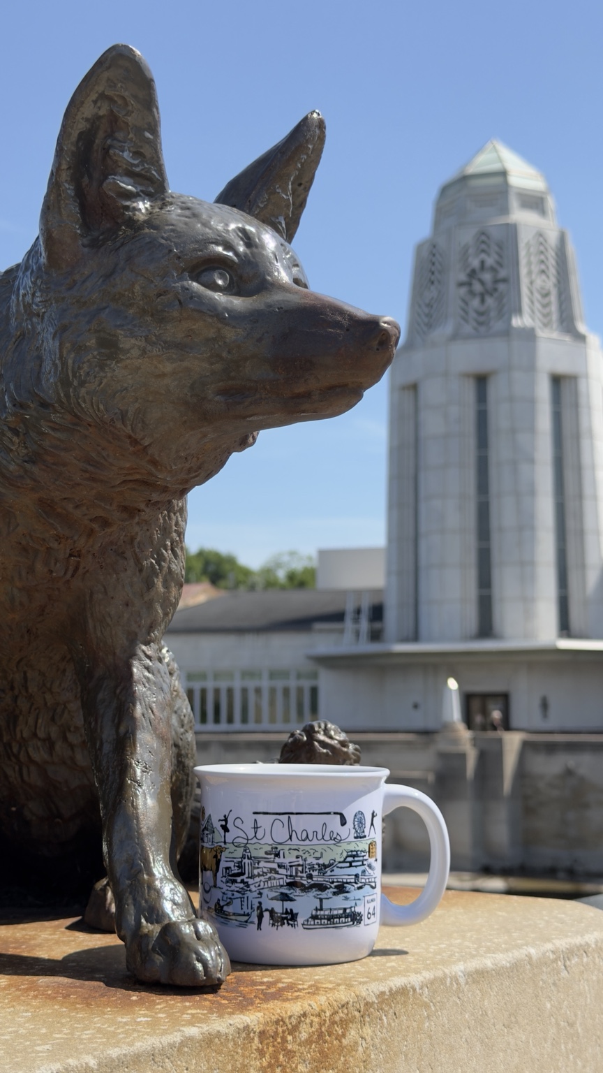 The St. Charles Mug beside the fox sculpture and Municipal Center