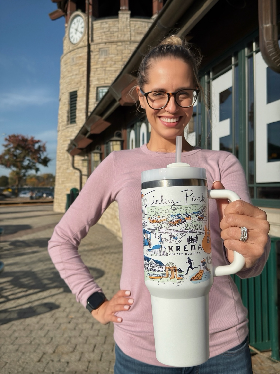 Ashley holding the Tinley Park tumbler outside Krema Coffee at the Oak Park Avenue train station