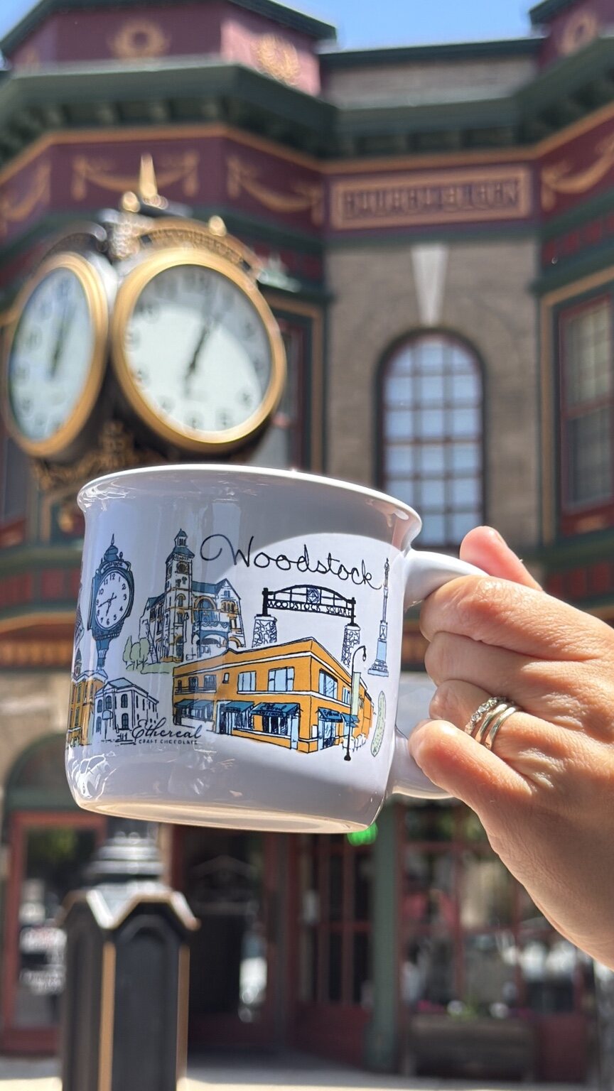 The Woodstock Mug held in front of the Woodstock Square clock